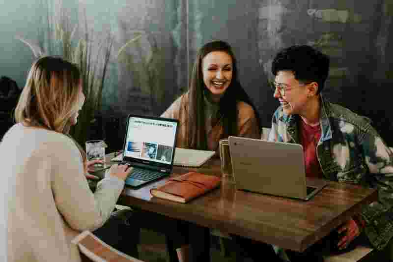 Lachende Gruppe von jungen Leuten mit Laptops - Ratgeber Social Media Studium: Campus M University.