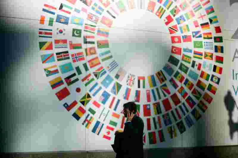 Business Manager vor einer Wand mit Flaggen – Ratgeber International Business Studium: Campus M University.