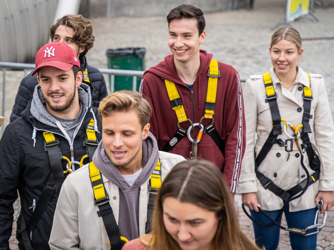 Menschen in Kletterausrüstung laufen zusammen