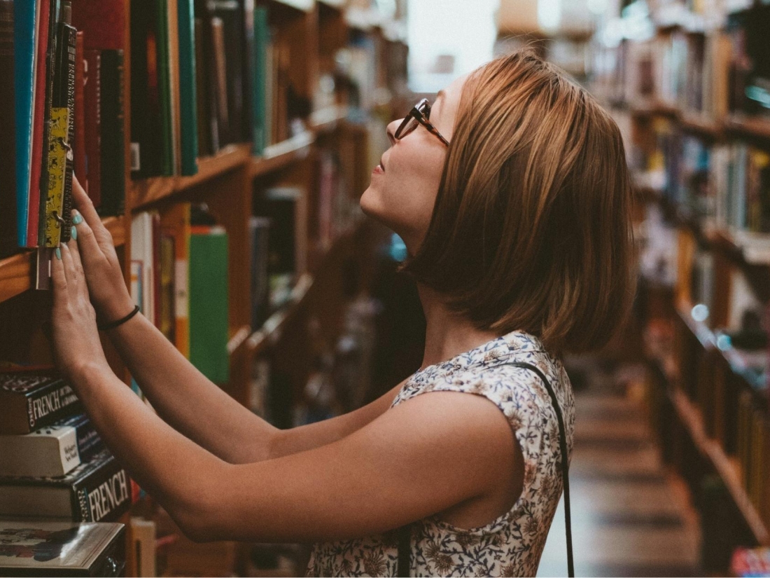 Studentin in einer Bibliothek der Uni Nürnberg sucht ein Buch.
