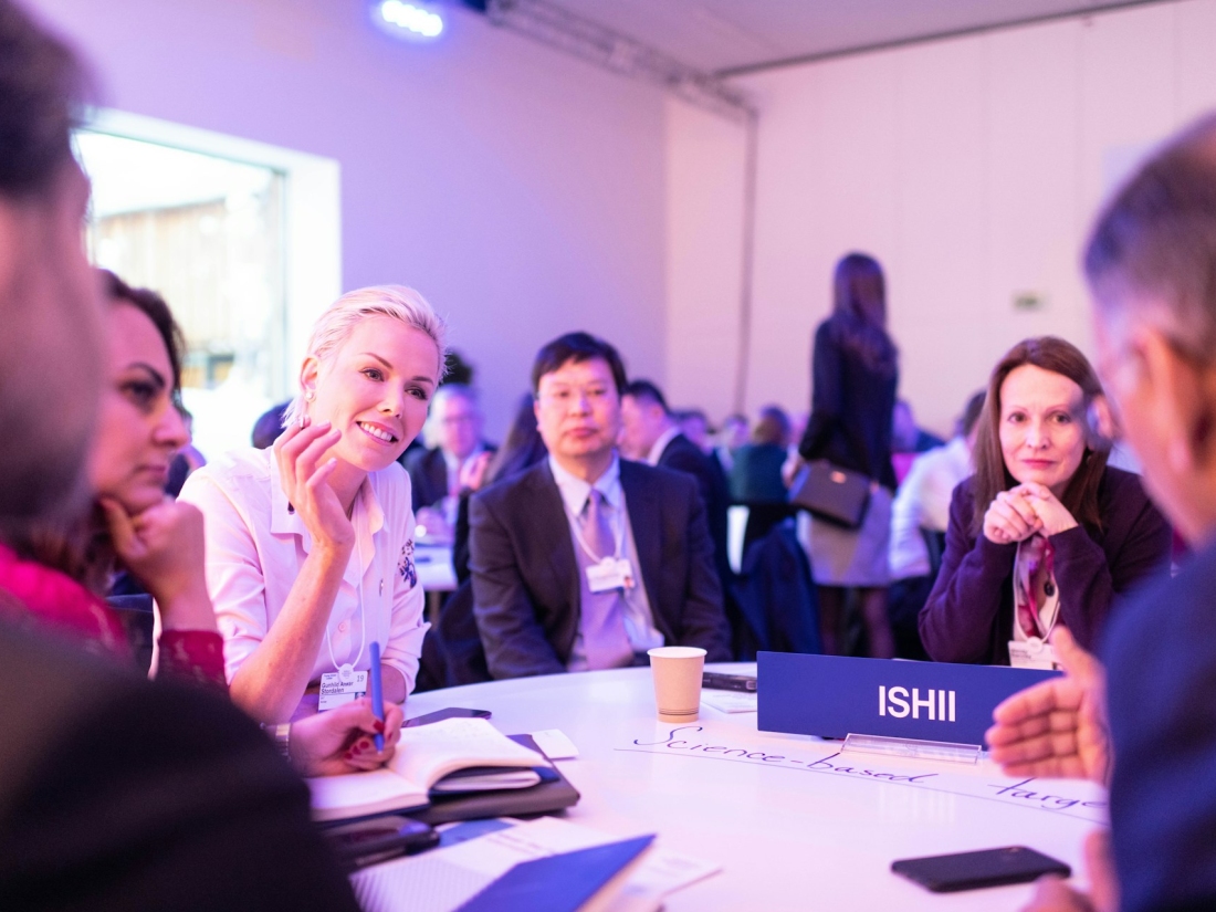 Personen sitzen bei einem Event am Tisch und haben eine Besprechung – Master Sportmanagement