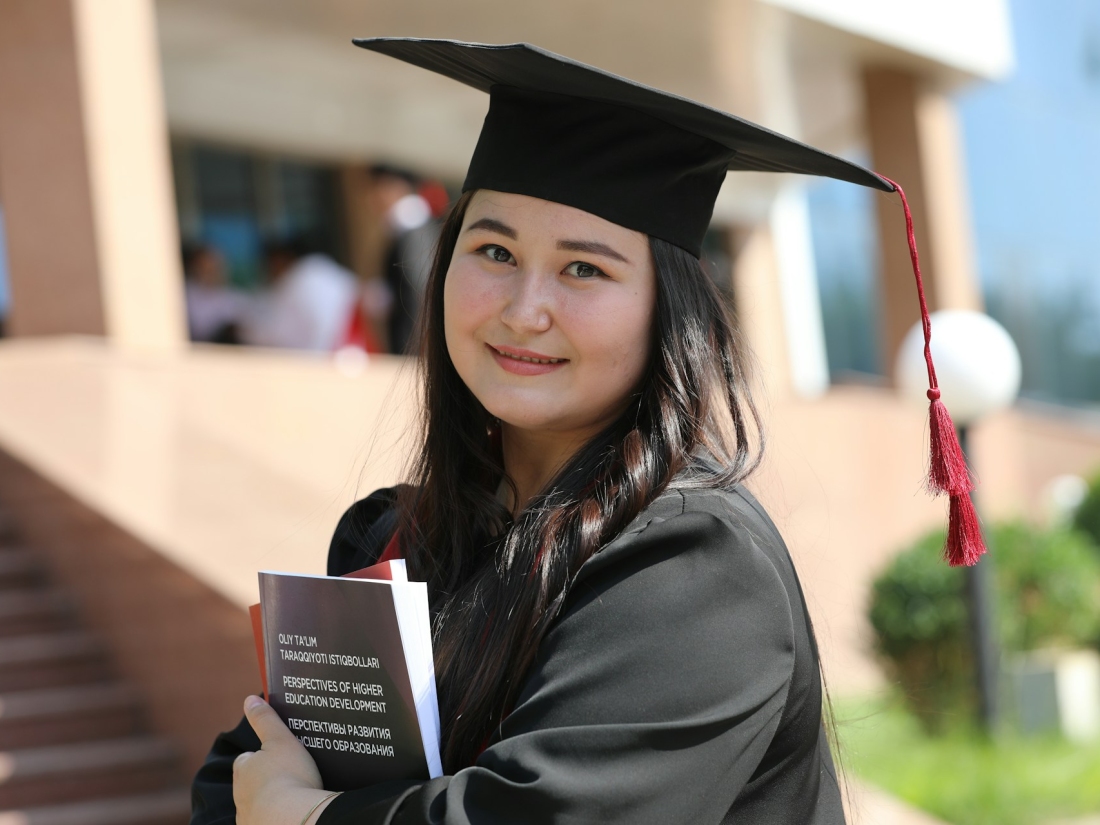 Studierende und Absolventenkappe und Abschluss in der Hand.