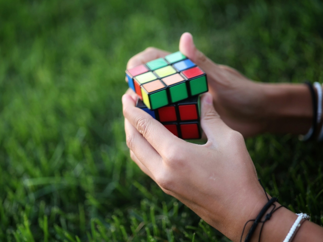 Hände halten einen Zauberwürfel – Symbol für Psychologie Studium, Analyse und Problemlösung.