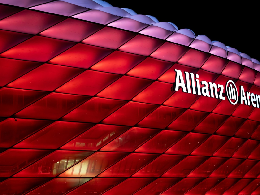 Außenansicht der Allianz Arena bei Nacht mit roter Beleuchtung